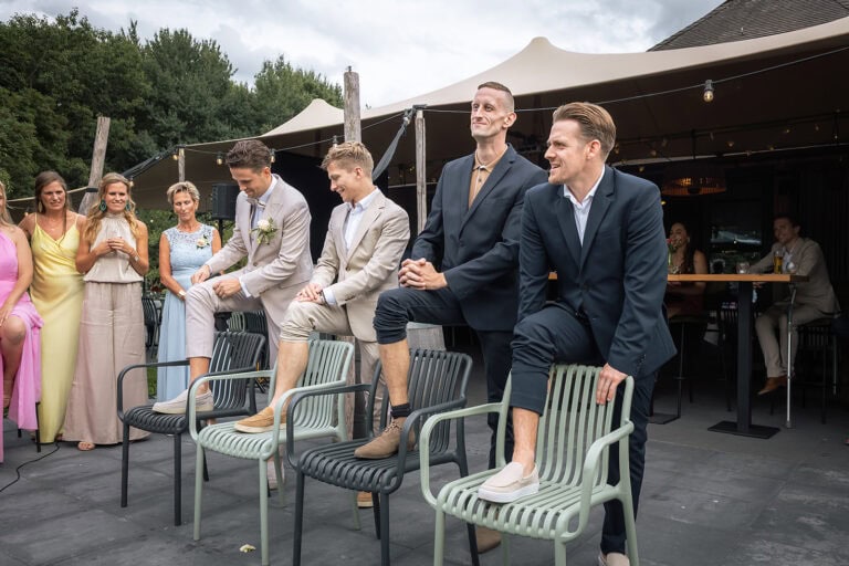Bruidegom en groomsmen doen een challenge voor de geblinddoekte bruid