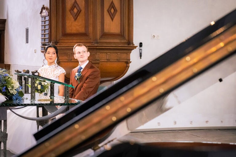 Kiko en Onno tijdens de ceremonie in de Oude Kerk in Voorburg met piano en prachtige scherptediepte